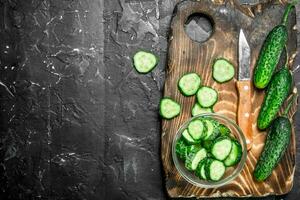 Sliced cucumbers on a cutting Board with a knife. photo