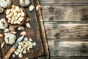 Garlic cloves on a cutting Board with a knife. photo