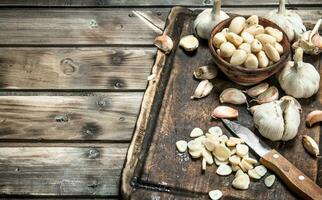 Garlic cloves on a cutting Board with a knife. photo