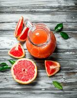 Grapefruit juice in a glass pitcher. photo