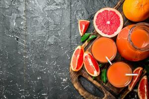 Juice of ripe grapefruit in a jug on a cutting Board. photo