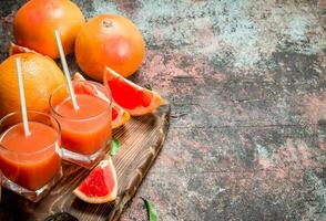 Grapefruit juice in a glass on a cutting Board. photo