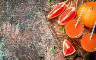 Grapefruit juice in a glass on a cutting Board. photo