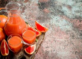 Grapefruit juice in a glass on a cutting Board. photo