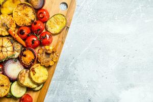 Grilled vegetables with spices and herbs on a cutting Board. photo