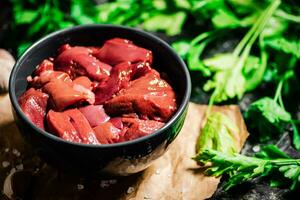 Raw liver in a bowl with parsley. photo