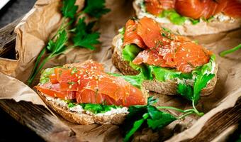 Salmon sandwich on paper. Macro background. photo