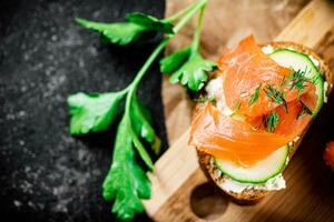 Salmon sandwich on a cutting board. photo