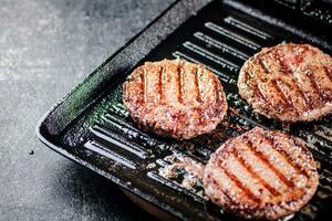 Cooking a delicious grilled burger on a pan with oil bubbles. photo