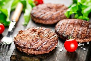 hamburguesa parrilla en un corte tablero con Tomates y verduras. foto