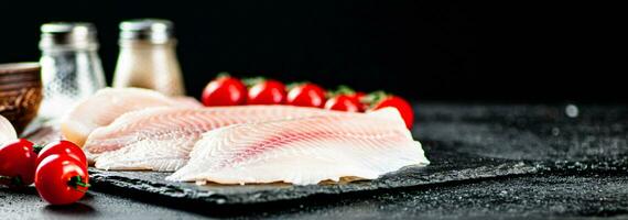 crudo pescado filete con Tomates y especias foto