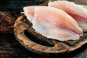 crudo pescado filete en un de madera corte tablero. foto