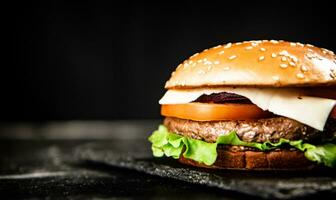 A burger on a stone board on a table. photo