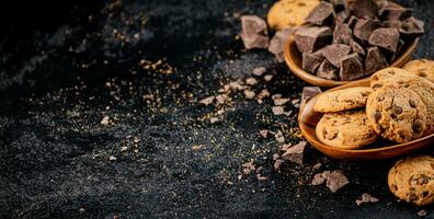 Wooden plate with cookies and pieces of milk chocolate. photo