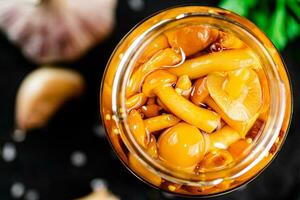 Marinated mushrooms with a glass jar with parsley and garlic. photo