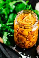 Marinated mushrooms with a glass jar with parsley and garlic. photo