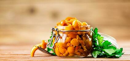 Glass jar with marinated mushrooms. photo