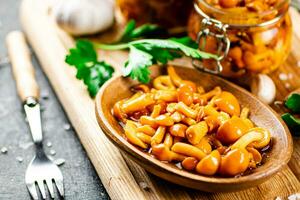 Marinated mushrooms with parsley on a wooden cutting board. photo