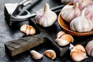 Garlic on a wooden plate on a cutting board. photo