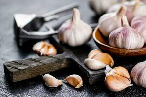 Garlic on a wooden plate on a cutting board. photo