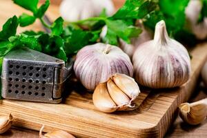 Garlic with parsley on a wooden cutting board. photo