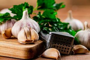 Garlic with parsley on a wooden cutting board. photo