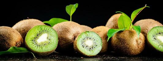 Juicy kiwi with greens on the table. photo