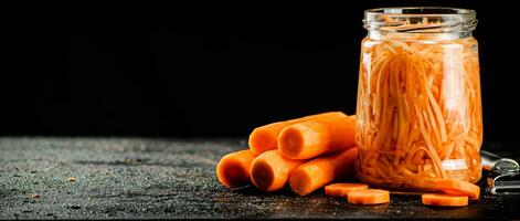 A glass jar with canned carrots. photo