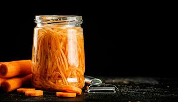 A glass jar with canned carrots. photo