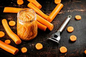 Canned carrots in a glass jar on the table. photo