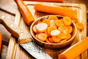 Sliced fresh carrots. On a wooden background. photo