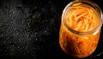 Canned carrots in a glass jar. photo