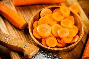 Sliced fresh carrots. On a wooden background. photo