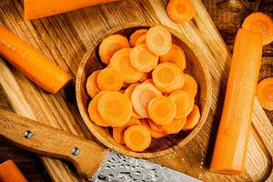 Sliced fresh carrots. On a wooden background. photo