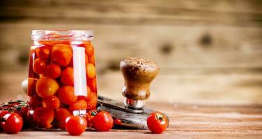 Pickled ripe tomatoes in a glass jar. photo