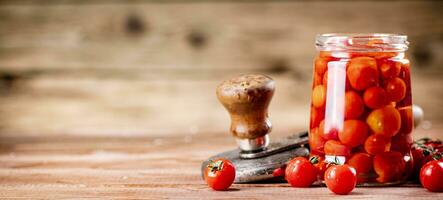 Pickled ripe tomatoes in a glass jar. photo