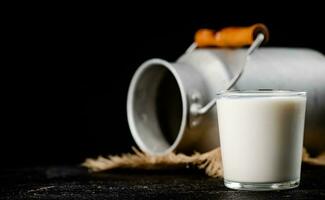 Fresh homemade milk on the table in a glass. photo