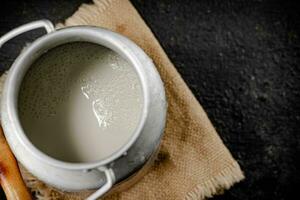 Fresh milk in a can on the table. photo