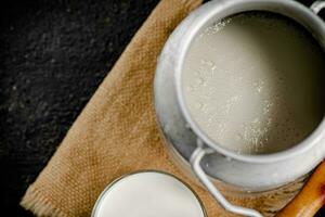 Fresh milk in a can on the table. photo