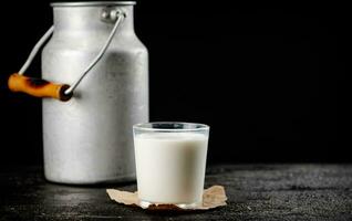 Fresco país Leche en un vaso en el mesa. foto