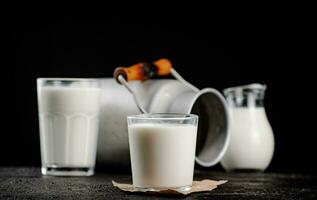 Fresco país Leche en un vaso en el mesa. foto