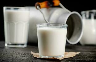 Fresh country milk in a glass on the table. photo