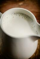 A jug of fresh milk on the table. photo