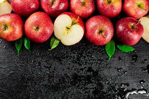 Whole and pieces of red apple with leaves. photo