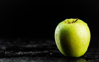 One fresh green apple on the table. photo