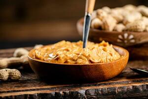 Peanut butter and inshell peanuts on a cutting board. photo