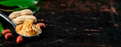 A spoonful of peanut butter on a table with leaves. photo