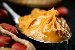 Spoon with peanut butter. Macro background. photo