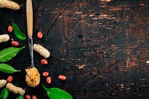 A spoonful of peanut butter on a table with leaves. photo