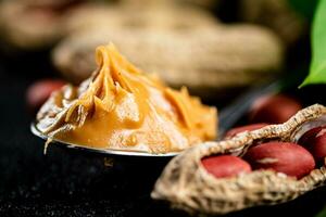 Spoon with peanut butter. Macro background. photo